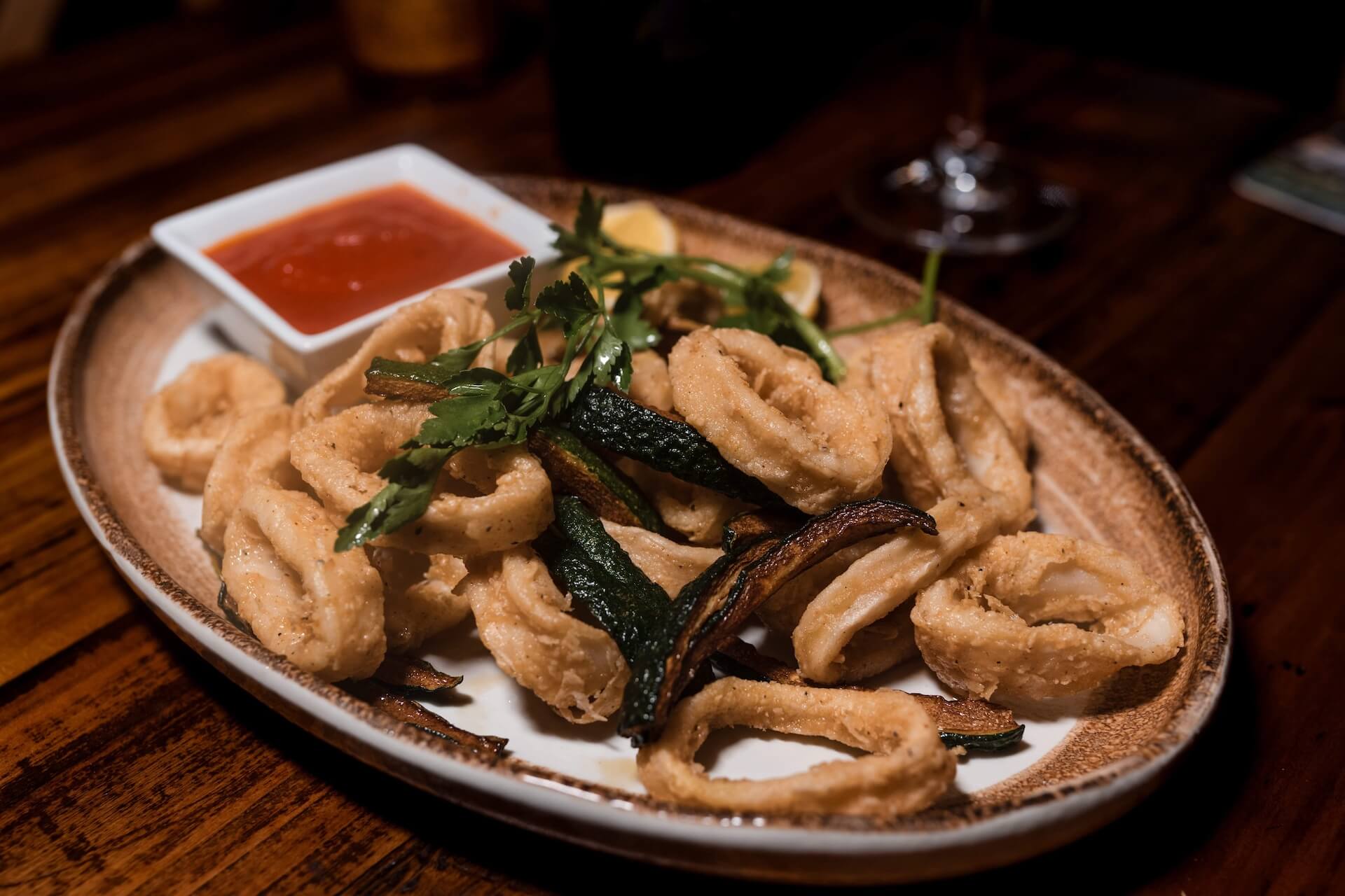Fried calamari with greens and a dish of red sauce