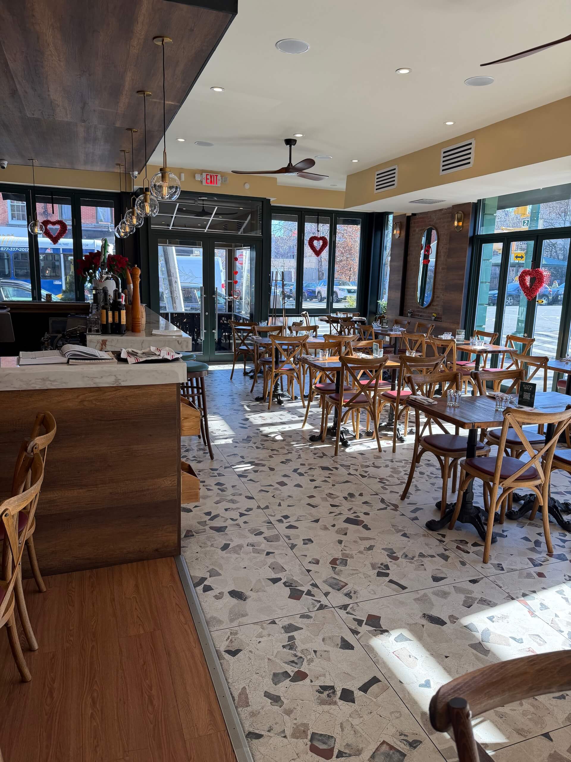 The dining room with a terrazzo floor, wooden tables and bentwood chairs